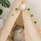 Primer plano de la entrada de la cama tipi de tela con un gato asomado de The Paws Boutique.